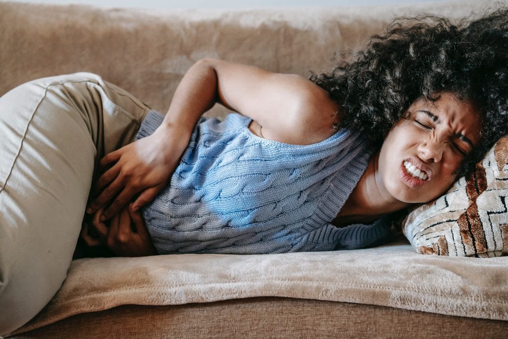 woman in couch suffering from pain